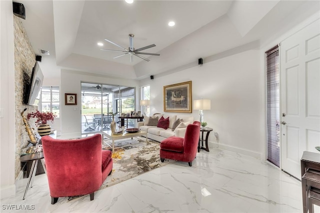 living area with visible vents, a tray ceiling, recessed lighting, baseboards, and ceiling fan