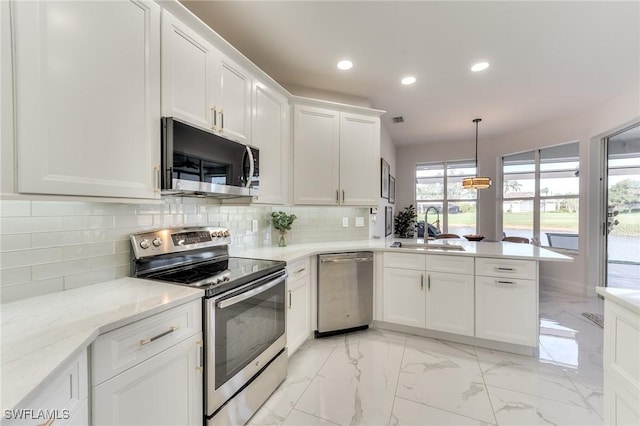 kitchen with appliances with stainless steel finishes, white cabinets, a peninsula, marble finish floor, and a sink