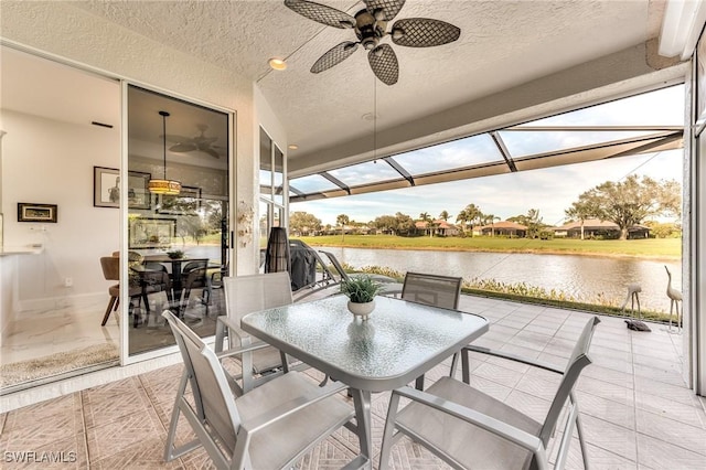 view of patio with outdoor dining space, a lanai, a water view, and ceiling fan