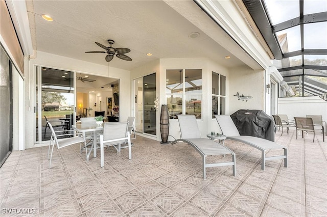 view of patio / terrace with glass enclosure, a grill, and ceiling fan