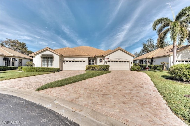 ranch-style house with decorative driveway, a front yard, an attached garage, and stucco siding