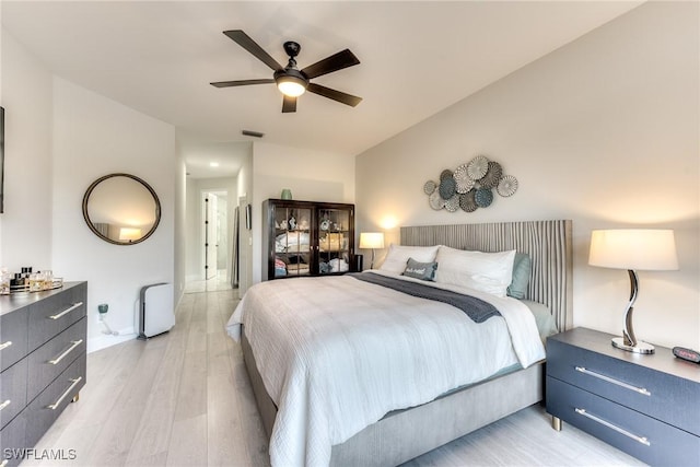 bedroom with visible vents, light wood-style floors, and ceiling fan