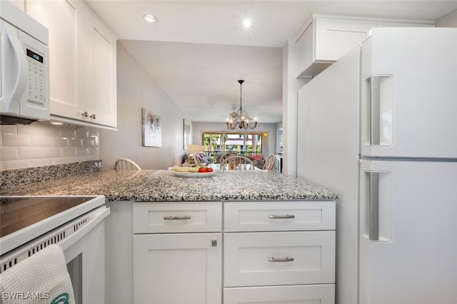 kitchen with white cabinetry, tasteful backsplash, kitchen peninsula, a chandelier, and white appliances