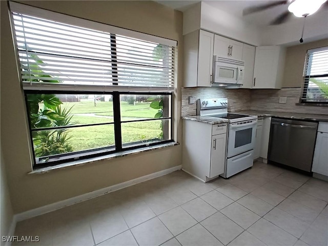 kitchen with white appliances, light tile patterned floors, ceiling fan, decorative backsplash, and white cabinets