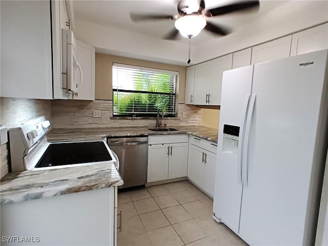 kitchen featuring sink, white cabinetry, light tile patterned floors, white appliances, and backsplash