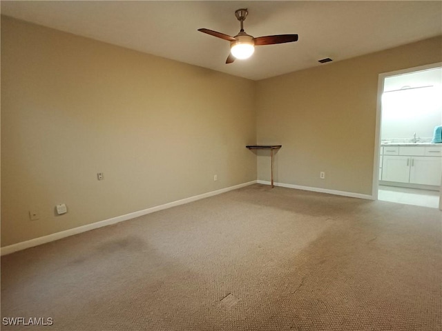 empty room featuring ceiling fan, sink, and carpet