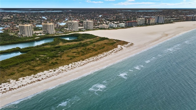 birds eye view of property with a water view and a beach view