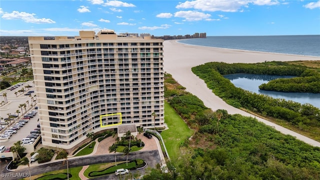 view of building exterior with a beach view and a water view