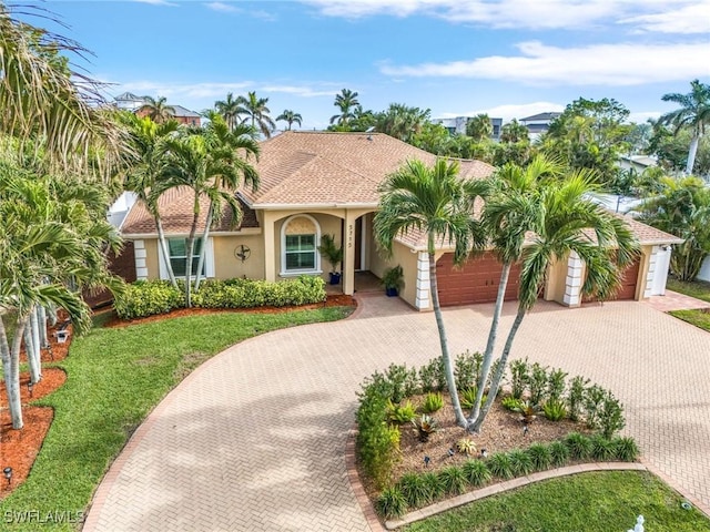 mediterranean / spanish home with a front yard and a garage