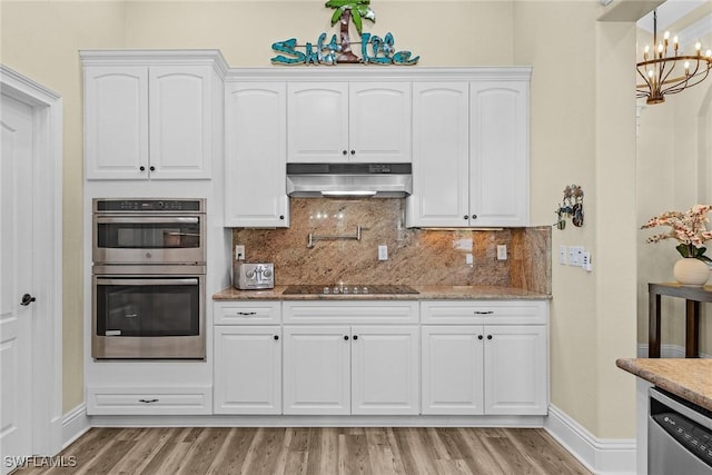 kitchen with stainless steel appliances, an inviting chandelier, light hardwood / wood-style flooring, decorative backsplash, and white cabinets