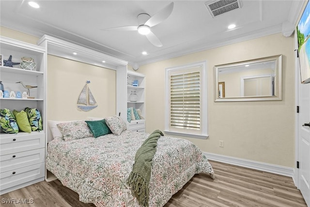 bedroom with hardwood / wood-style flooring, ceiling fan, and ornamental molding