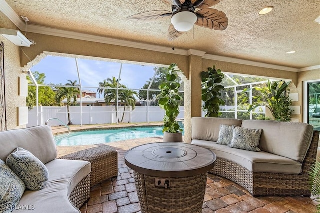 sunroom / solarium with plenty of natural light, ceiling fan, and a swimming pool