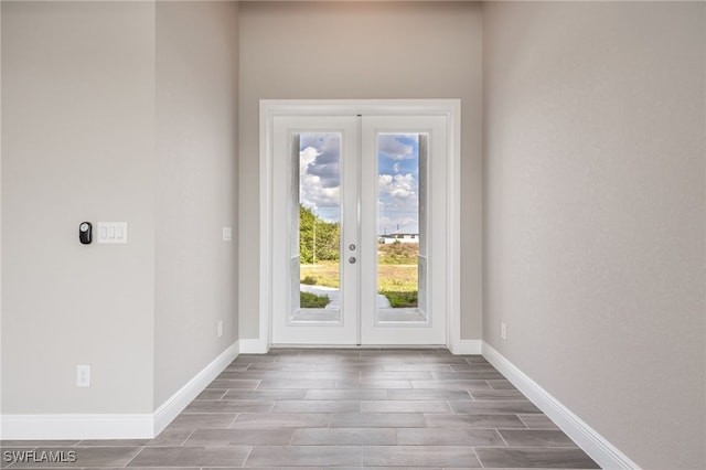 doorway with wood tiled floor, baseboards, and french doors