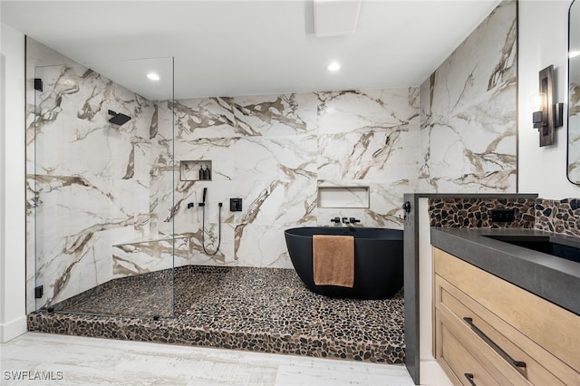 bathroom with vanity, tile walls, and walk in shower