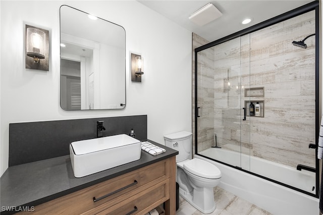 full bathroom featuring vanity, bath / shower combo with glass door, and toilet