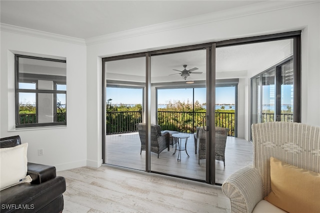 doorway to outside with a wealth of natural light, light hardwood / wood-style flooring, ceiling fan, and crown molding