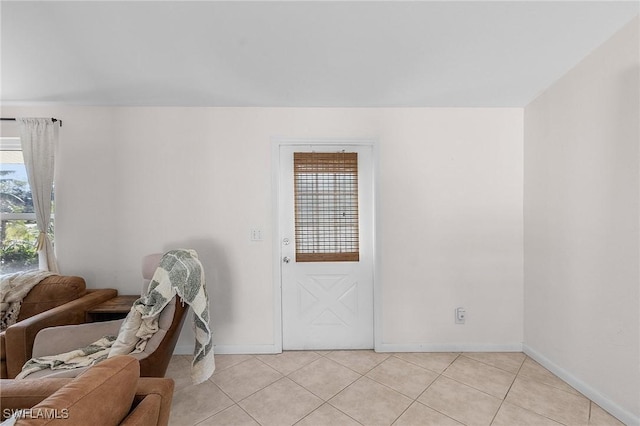 interior space with light tile patterned flooring, plenty of natural light, and baseboards