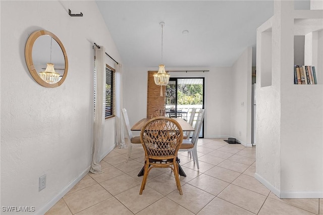 dining area featuring vaulted ceiling, light tile patterned floors, a chandelier, and baseboards