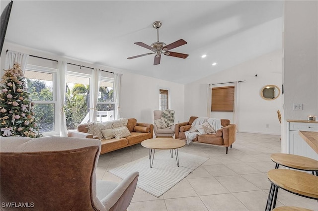 living area featuring a ceiling fan, lofted ceiling, and light tile patterned flooring