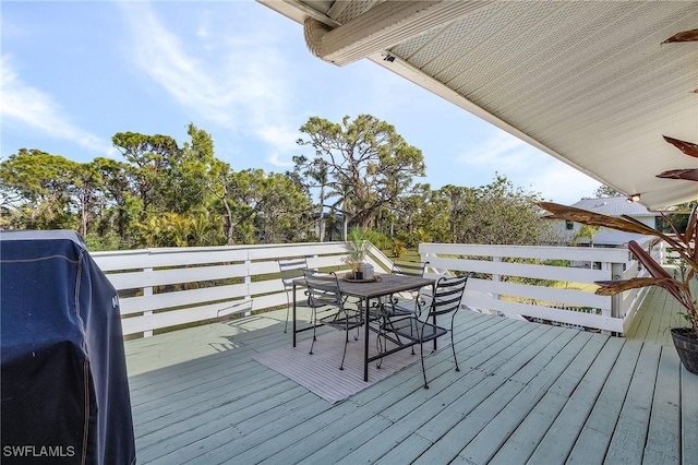 wooden deck with outdoor dining space and a grill