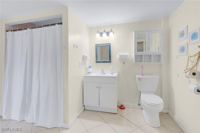 bathroom with toilet, baseboards, vanity, and tile patterned floors