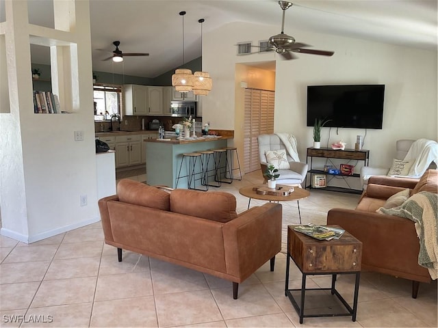 living area featuring baseboards, visible vents, a ceiling fan, lofted ceiling, and light tile patterned flooring