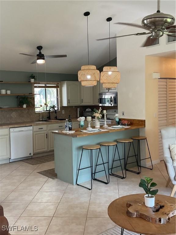 kitchen with ceiling fan, white dishwasher, stainless steel microwave, and a sink