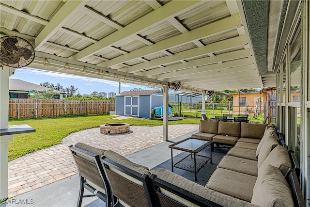 view of patio featuring a storage unit and an outdoor living space with a fire pit