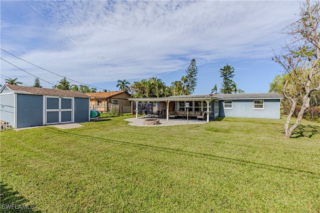 rear view of house featuring a yard, an outdoor fire pit, a patio area, and a storage unit