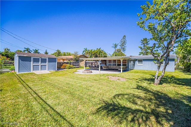 view of yard featuring a patio, a fire pit, and a storage unit