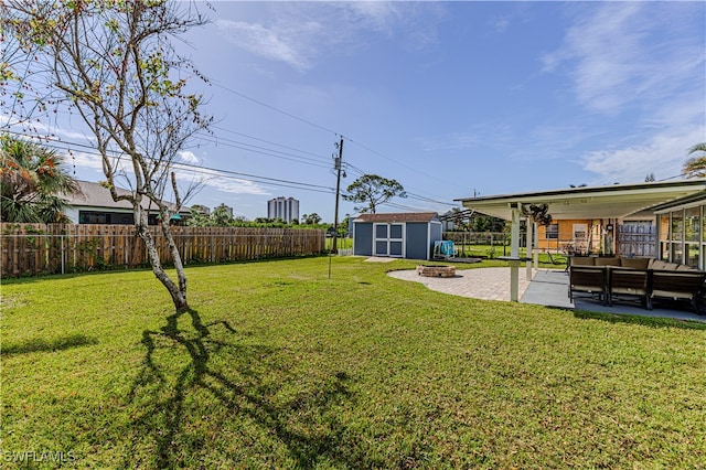 view of yard with a fire pit, a patio area, and a storage shed