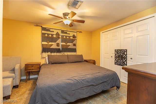 bedroom with ceiling fan and dark tile patterned flooring