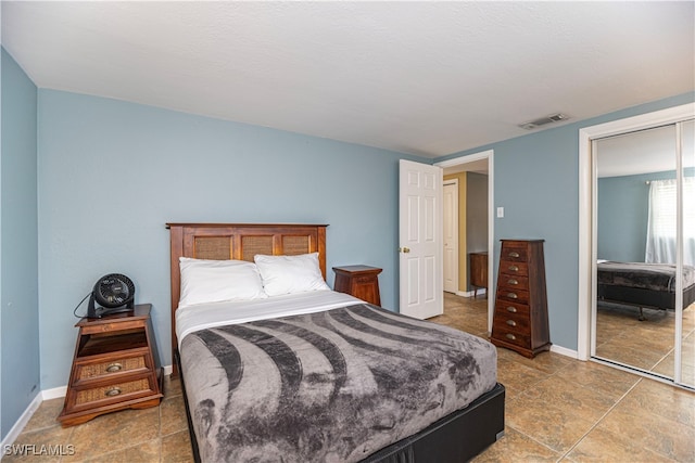 bedroom with tile patterned floors and a closet