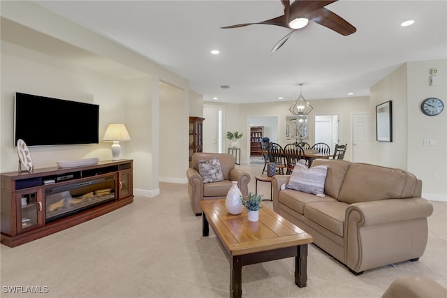 living room with light tile patterned floors and ceiling fan with notable chandelier