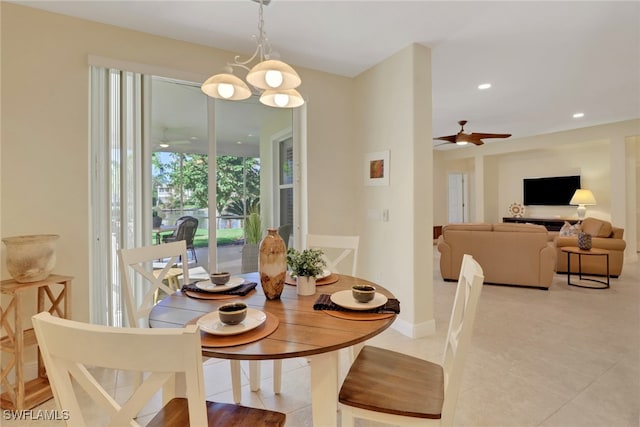 dining space with light tile patterned floors and ceiling fan with notable chandelier