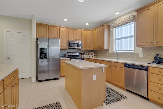 kitchen featuring sink, a kitchen island, light tile patterned flooring, and appliances with stainless steel finishes