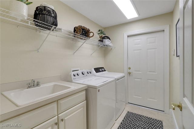 laundry area featuring light tile patterned flooring, cabinets, sink, and washing machine and clothes dryer