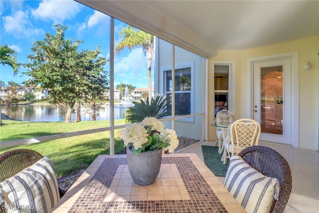 sunroom featuring a water view