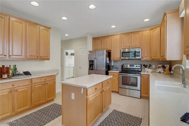 kitchen with a center island, sink, light tile patterned floors, light brown cabinetry, and appliances with stainless steel finishes