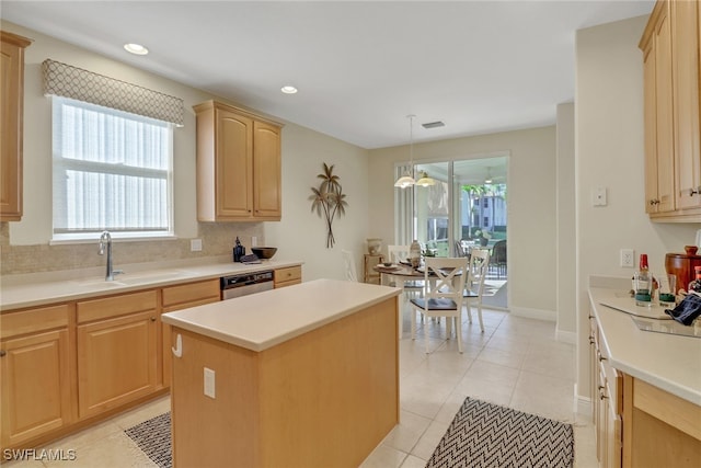 kitchen with sink, light brown cabinets, hanging light fixtures, a kitchen island, and light tile patterned flooring