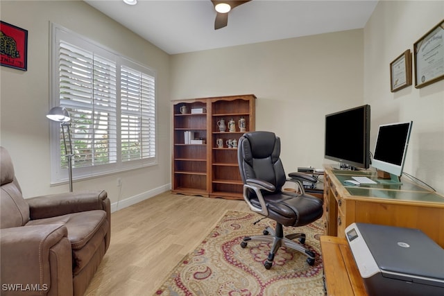 home office with light hardwood / wood-style flooring and ceiling fan