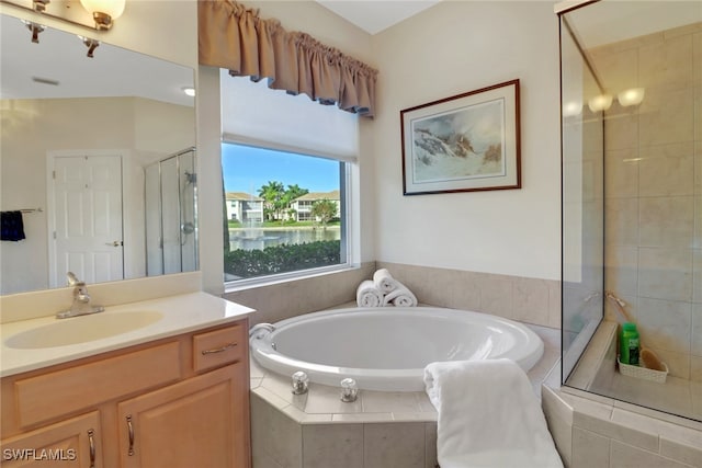 bathroom with vanity and shower with separate bathtub