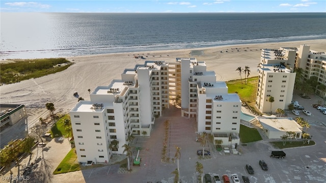 birds eye view of property featuring a water view and a beach view