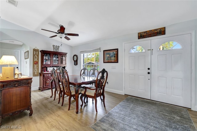 dining area featuring ceiling fan, vaulted ceiling, and light wood-type flooring