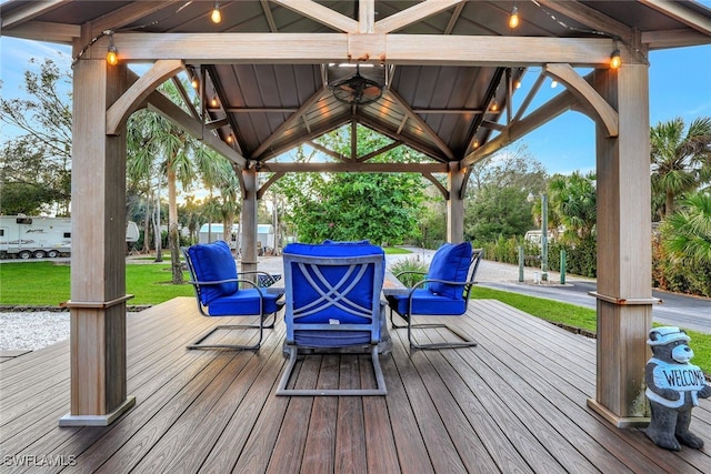 wooden deck with a gazebo, ceiling fan, and a lawn