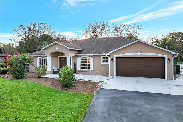 ranch-style house with a garage and a front lawn