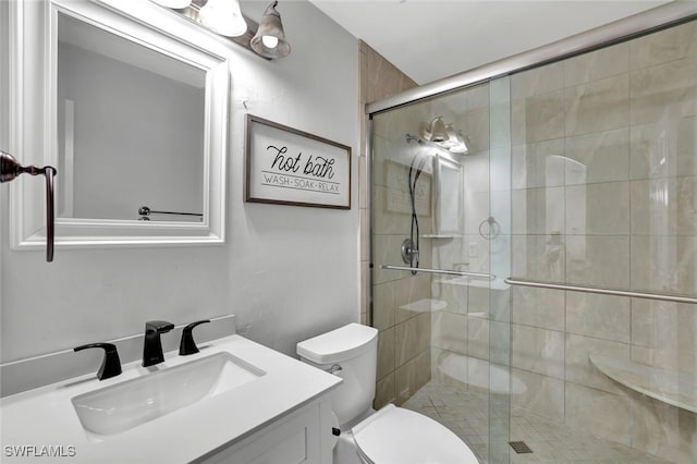 bathroom with vanity, toilet, and a shower with shower door