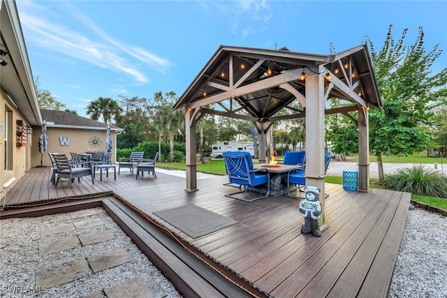 wooden terrace with a gazebo and an outdoor fire pit