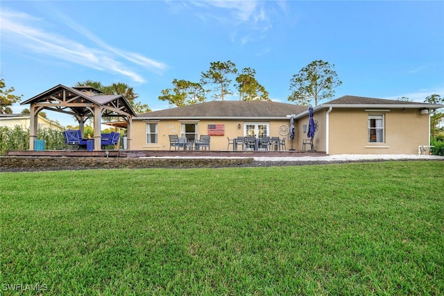 rear view of property with a gazebo, a patio, and a lawn