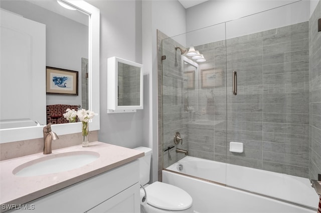 full bathroom featuring vanity, bath / shower combo with glass door, and toilet